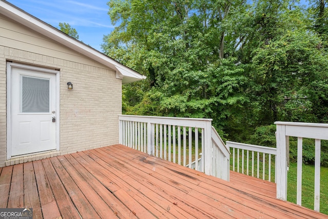 wooden terrace featuring a lawn