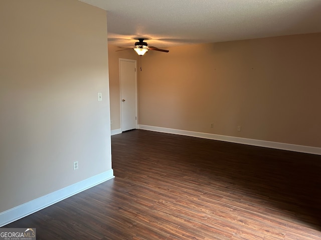 spare room featuring dark wood-type flooring, a textured ceiling, and ceiling fan