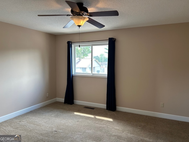 carpeted spare room with a textured ceiling and ceiling fan