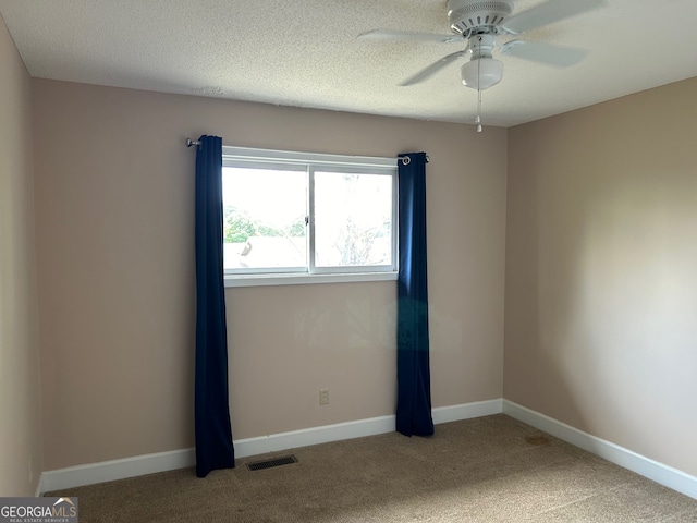 carpeted spare room with a textured ceiling and ceiling fan