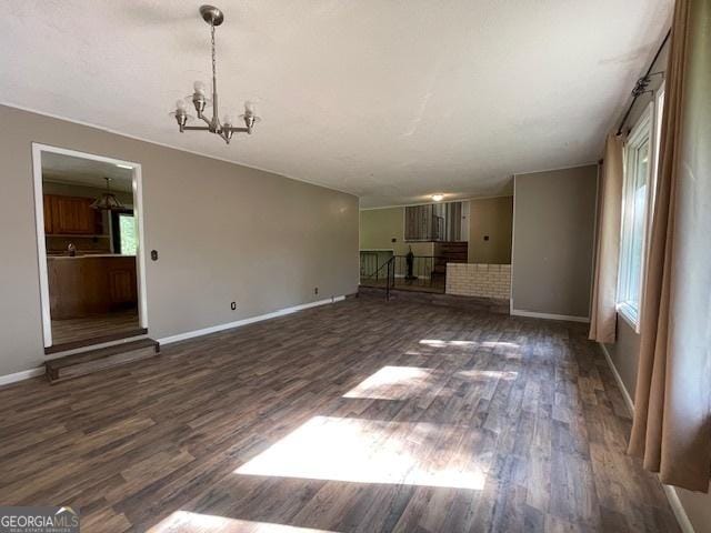 unfurnished living room featuring dark hardwood / wood-style floors and a chandelier