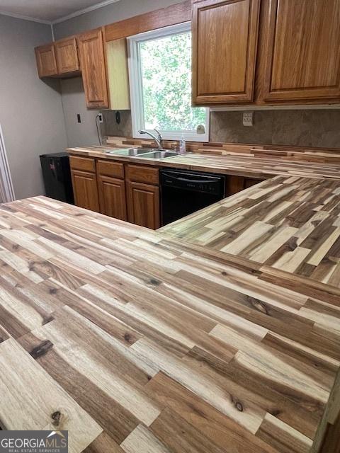 kitchen featuring butcher block counters, sink, ornamental molding, and dishwasher