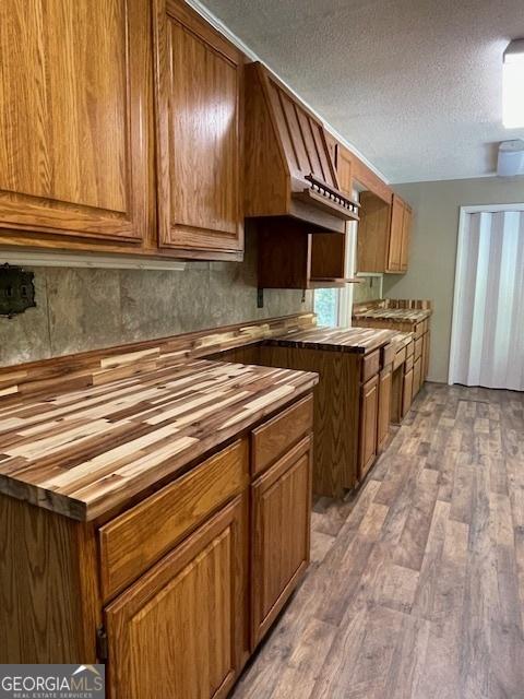 kitchen with wood counters, wood-type flooring, and a textured ceiling