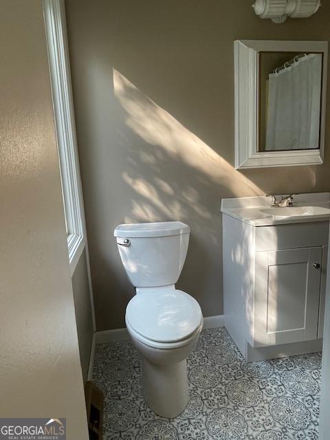 bathroom featuring tile patterned flooring, vanity, and toilet