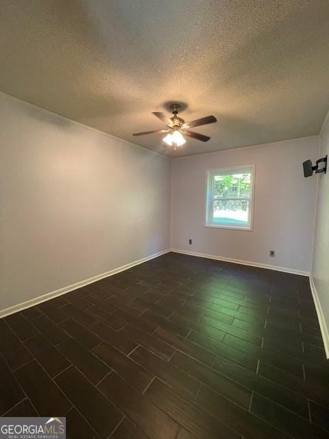 unfurnished room featuring ceiling fan, a textured ceiling, and dark hardwood / wood-style flooring