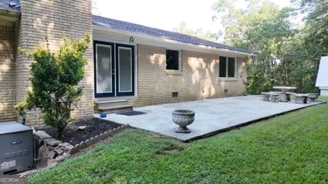 rear view of house featuring a lawn and a patio