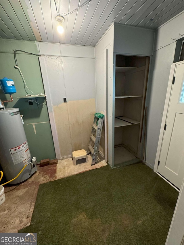 basement featuring wooden ceiling, water heater, and carpet flooring