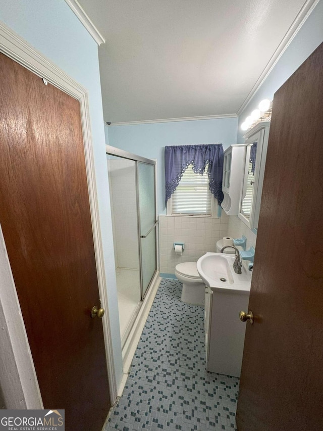 bathroom featuring vanity, an enclosed shower, tile walls, toilet, and ornamental molding