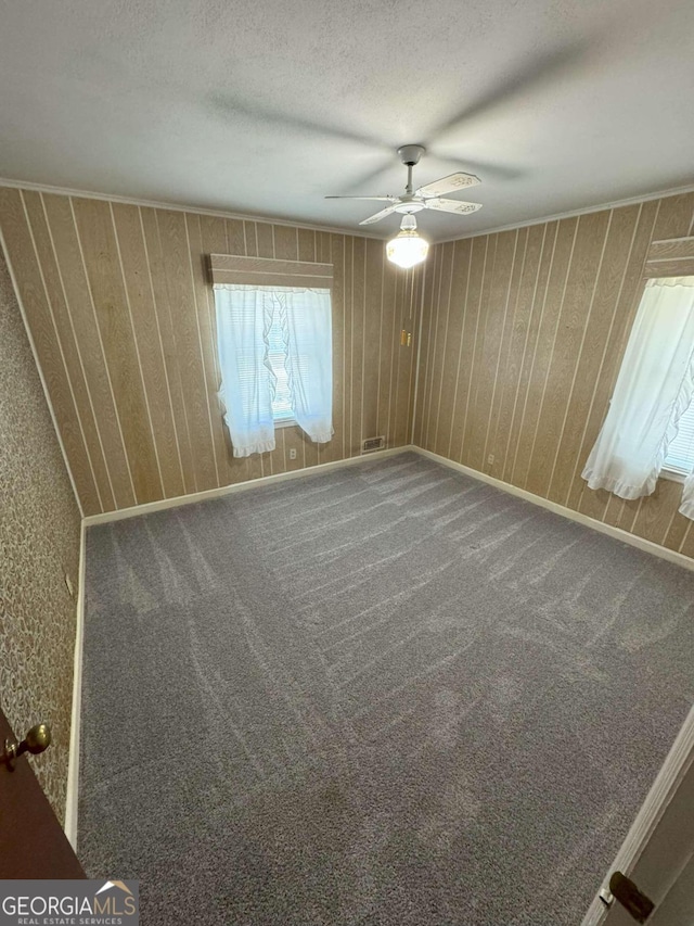 spare room with ceiling fan, a textured ceiling, and carpet floors