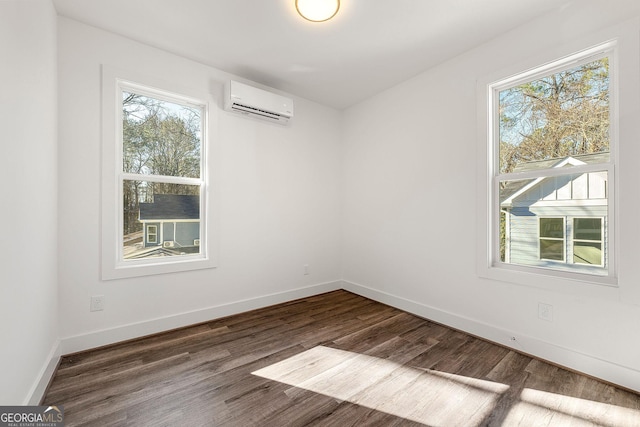 spare room featuring dark hardwood / wood-style floors, a healthy amount of sunlight, and a wall mounted AC