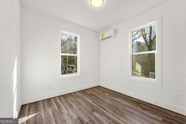 spare room with a wall mounted air conditioner and hardwood / wood-style flooring