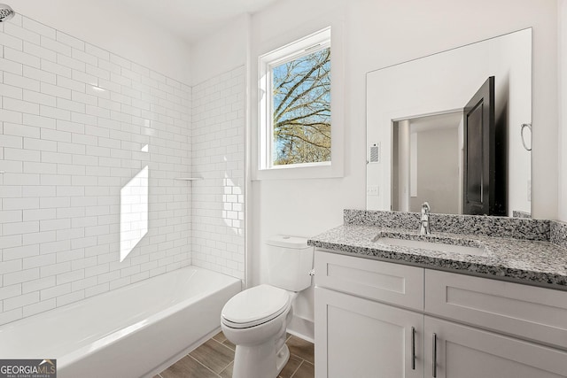 full bathroom with vanity, tiled shower / bath combo, and toilet