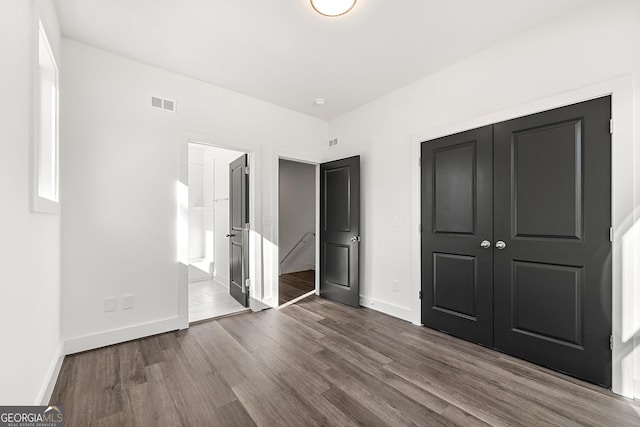 unfurnished bedroom with hardwood / wood-style floors and a closet