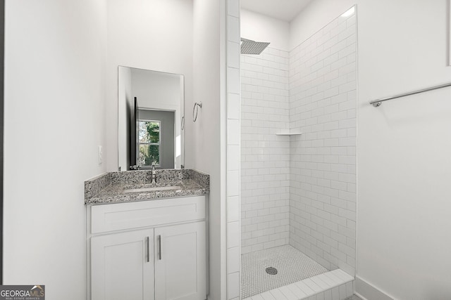 bathroom featuring vanity and tiled shower