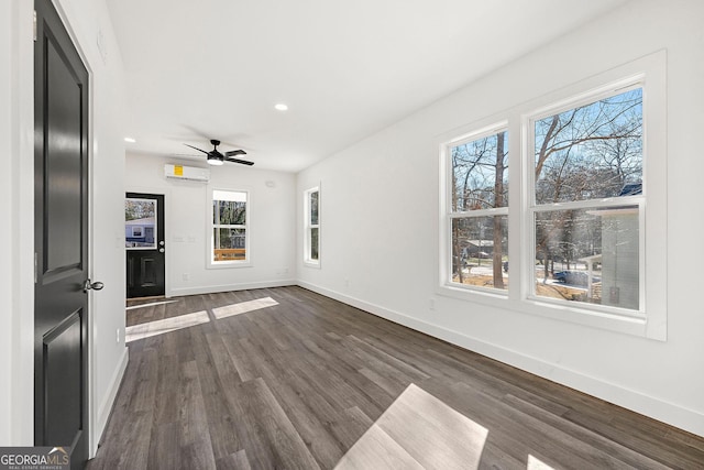 unfurnished living room featuring dark hardwood / wood-style floors, an AC wall unit, and ceiling fan