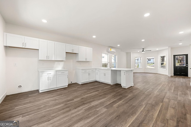 kitchen featuring ceiling fan, sink, dark wood-type flooring, kitchen peninsula, and white cabinets