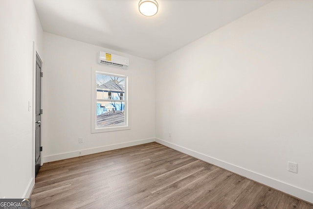 spare room featuring light hardwood / wood-style flooring and a wall mounted air conditioner