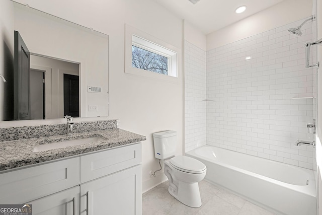 full bathroom with tile patterned flooring, vanity, tiled shower / bath combo, and toilet