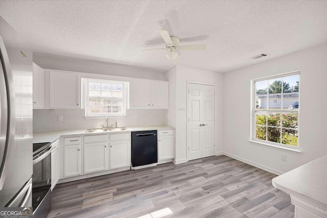 kitchen featuring appliances with stainless steel finishes, white cabinetry, a wealth of natural light, and sink