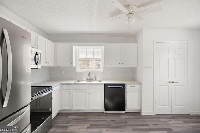 kitchen featuring white cabinets, appliances with stainless steel finishes, sink, wood-type flooring, and ceiling fan