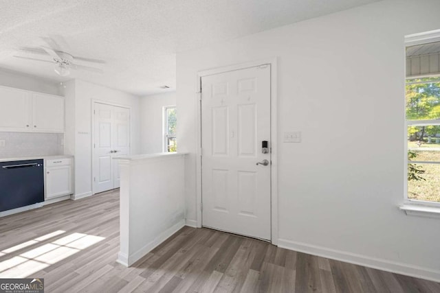 foyer entrance with a textured ceiling, light hardwood / wood-style flooring, and ceiling fan