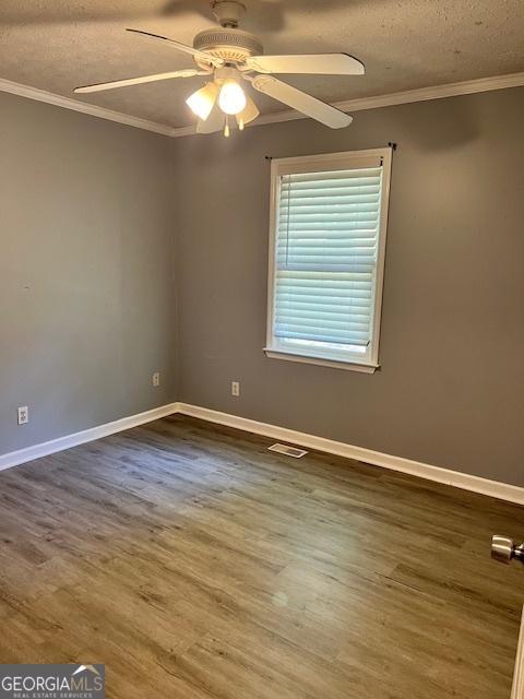 unfurnished room with ceiling fan, a textured ceiling, wood-type flooring, and ornamental molding