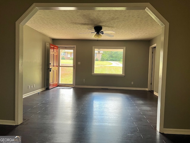 unfurnished room with dark wood-type flooring, ceiling fan, and a textured ceiling