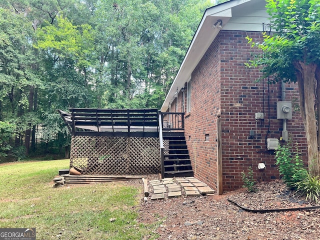 view of side of property with a yard and a wooden deck