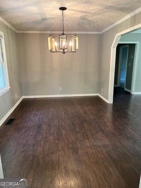 empty room featuring ornamental molding, dark hardwood / wood-style floors, and a textured ceiling