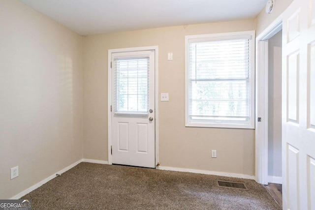 doorway with a healthy amount of sunlight and carpet