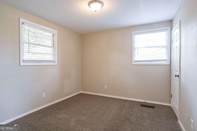 unfurnished room with a wealth of natural light and carpet