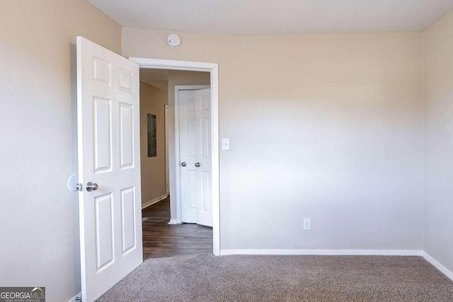 spare room featuring dark colored carpet