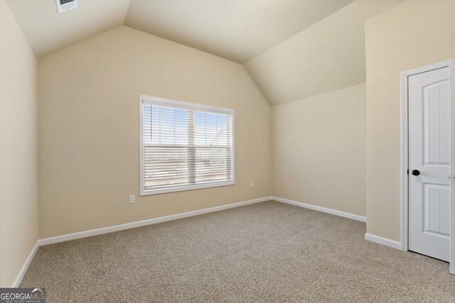 additional living space with vaulted ceiling and light colored carpet