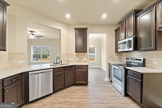 kitchen featuring light hardwood / wood-style flooring, sink, ceiling fan, decorative backsplash, and appliances with stainless steel finishes