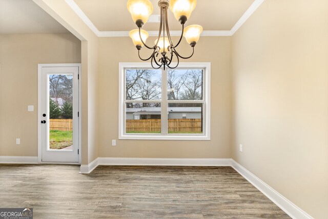 unfurnished dining area featuring crown molding, a notable chandelier, and light hardwood / wood-style flooring