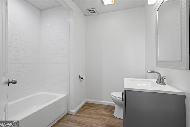 bathroom with wood-type flooring, toilet, a textured ceiling, and vanity