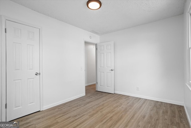 unfurnished bedroom featuring light hardwood / wood-style floors and a textured ceiling