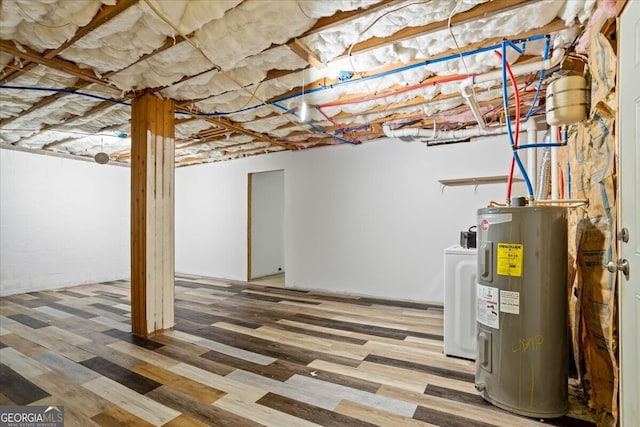 basement with washer / dryer, hardwood / wood-style floors, and water heater