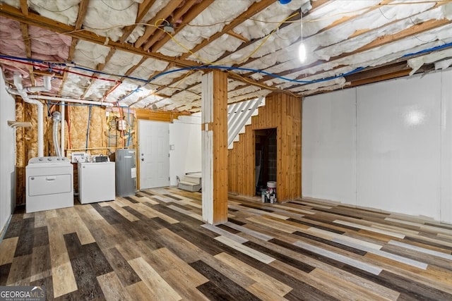 basement with separate washer and dryer, wood-type flooring, and water heater