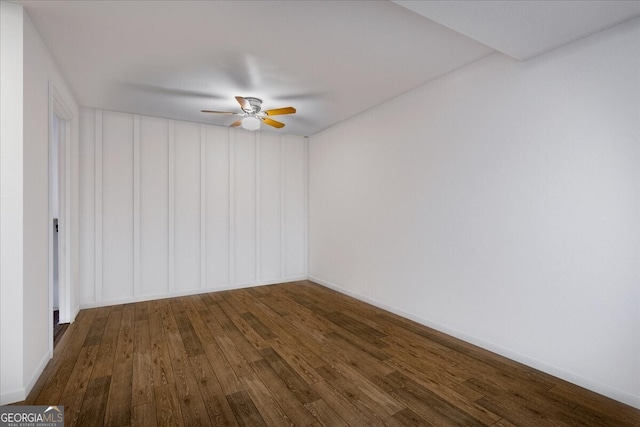 spare room with dark wood-type flooring and ceiling fan