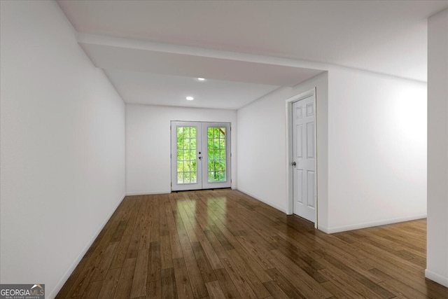 spare room featuring french doors and dark wood-type flooring