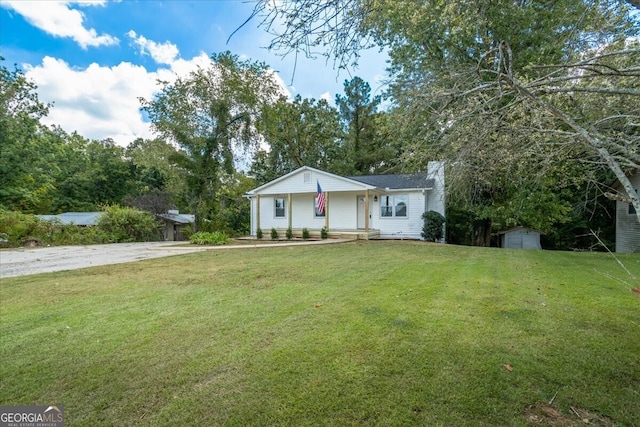 view of front of house featuring a storage shed and a front lawn