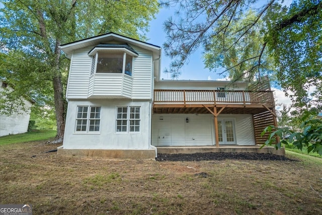 back of property featuring french doors, a deck, and a lawn