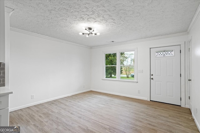 foyer featuring a textured ceiling, light hardwood / wood-style flooring, and ornamental molding