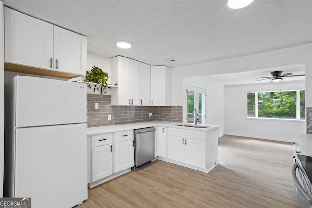 kitchen with appliances with stainless steel finishes, light hardwood / wood-style floors, sink, ceiling fan, and white cabinets