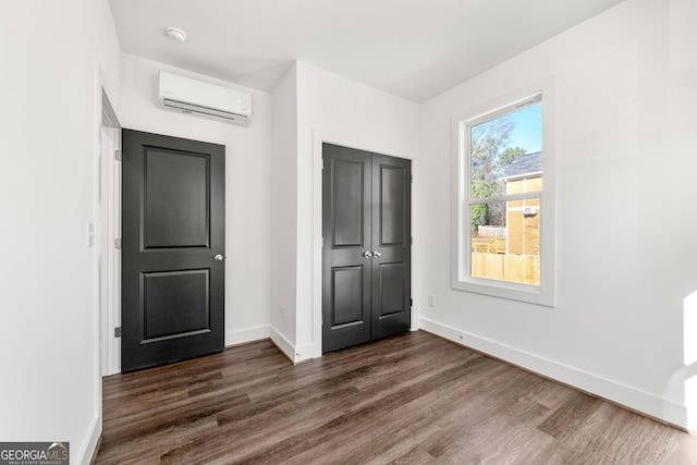 interior space featuring multiple windows, a closet, dark hardwood / wood-style floors, and a wall mounted AC