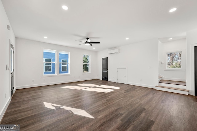 unfurnished living room featuring ceiling fan, dark hardwood / wood-style flooring, and a wall mounted air conditioner