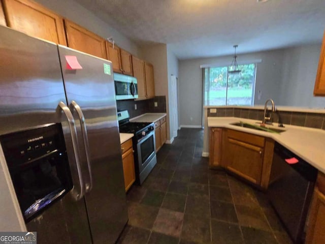 kitchen with backsplash, sink, decorative light fixtures, and appliances with stainless steel finishes