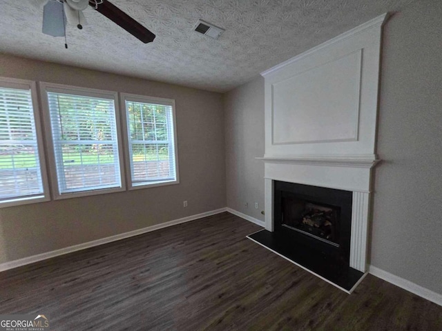 unfurnished living room with dark wood-type flooring, ceiling fan, and a textured ceiling