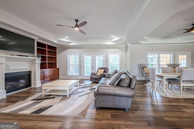 living room with dark hardwood / wood-style flooring, french doors, a tray ceiling, ornamental molding, and ceiling fan